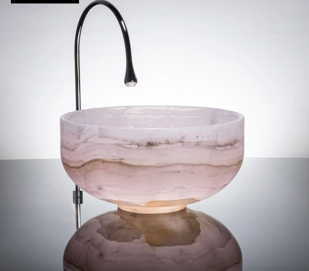 Stone Forest Tazza hand-carved pink onyx vessel sink with a sleek black faucet.