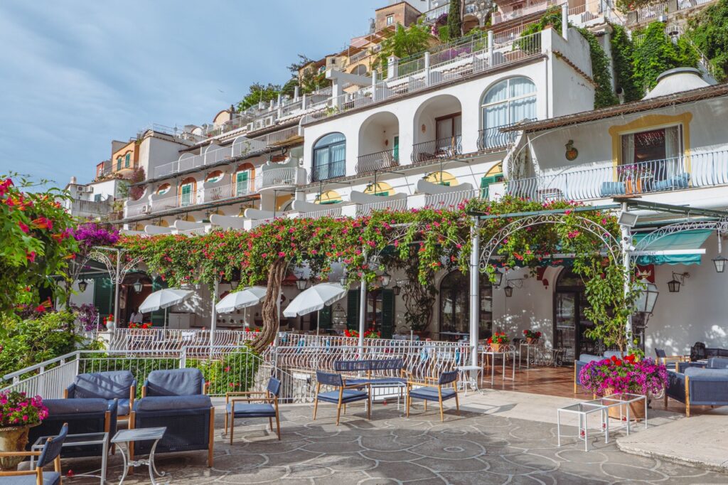 Hotel Poseidon terrace in Positano, Italy, with colorful flowers and seating.