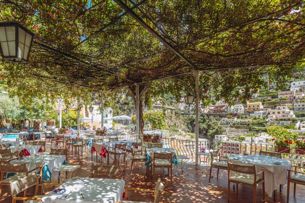 Hotel Poseidon restaurant terrace in Positano, Italy, with tables set and view of the coast