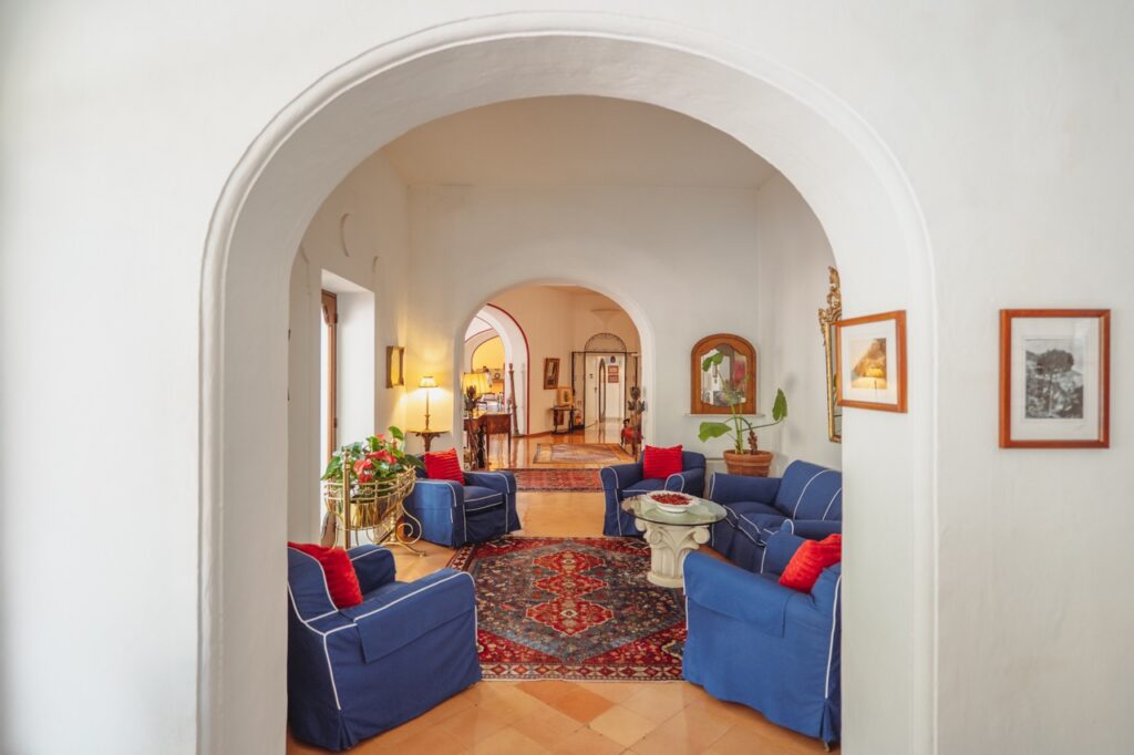 Hotel Poseidon Positano: Blue sofas and red rug in elegant Italian hotel lounge