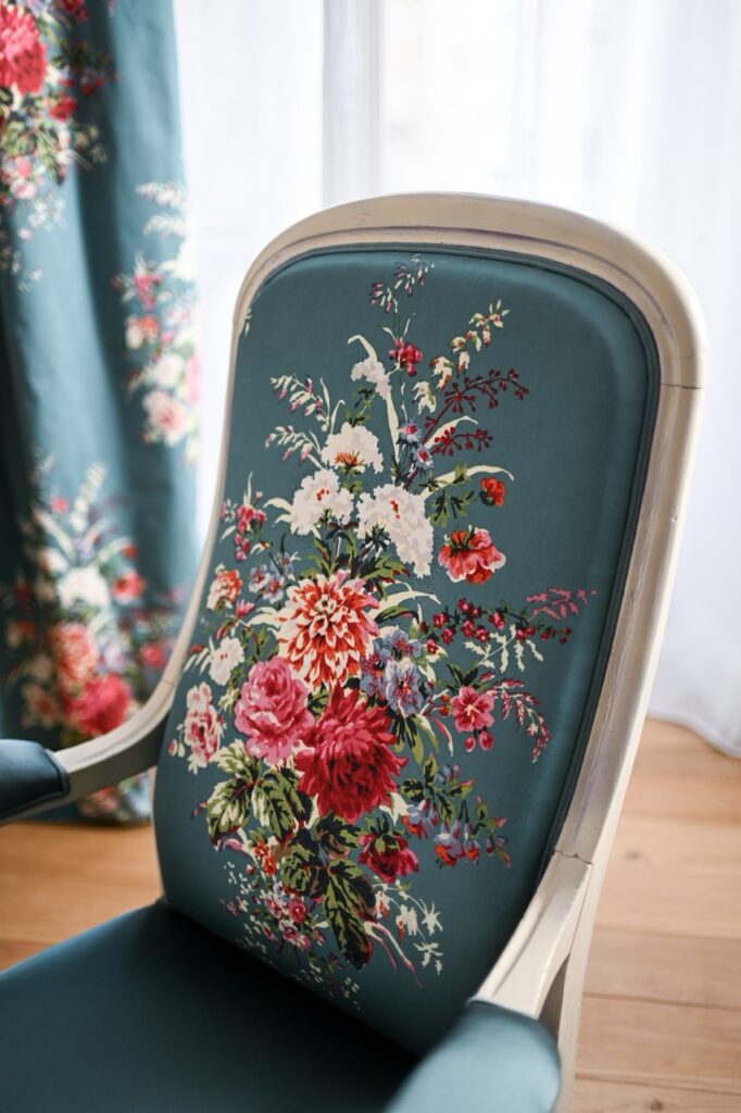 Armchair with floral pattern upholstery, featuring a bold floral design in rich colors.