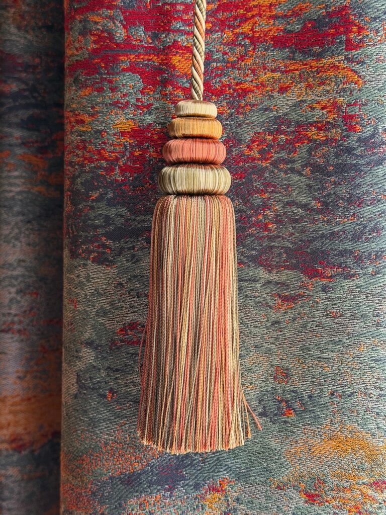 Textured tassel with stacked wooden beads on colorful patterned fabric