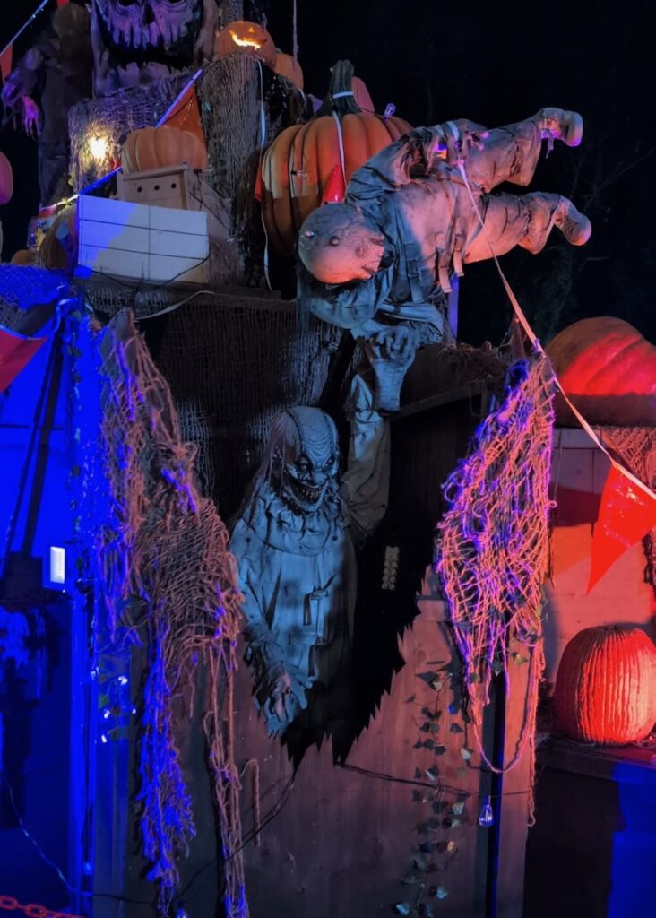 Scary Halloween decorations at Hundred Acres Manor, including creepy figures and pumpkins.