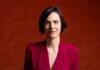 Quantum Theatre Names Katie Brook New Artistic Director Katie Brook, new Artistic Director of Quantum Theatre, in a red blazer.