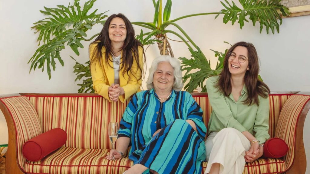 Three women smiling on a striped sofa at Hotel Poseidon, Positano