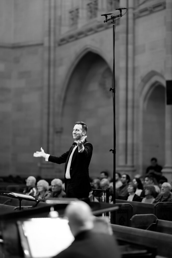Conductor leading the Mendelssohn Choir of Pittsburgh in a grand performance.