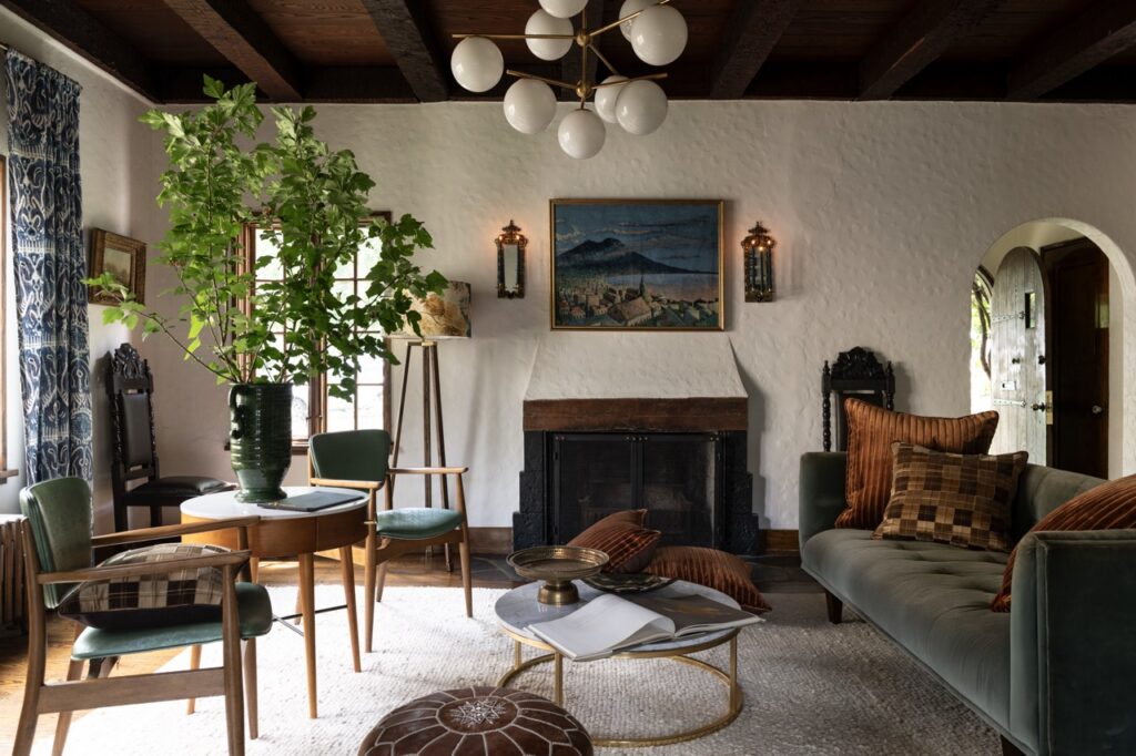 Mt. Lebanon cottage living room with fireplace, green sofa, and arched doorway