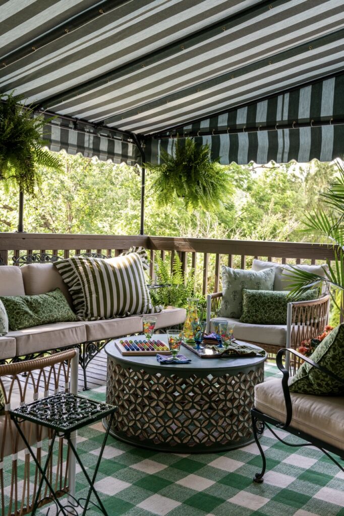 Mt. Lebanon fairy tale cottage porch with striped awning, rattan furniture, and green plaid rug.
