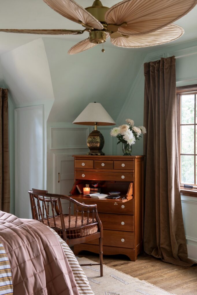 Fairy tale cottage bedroom with antique writing desk and fan