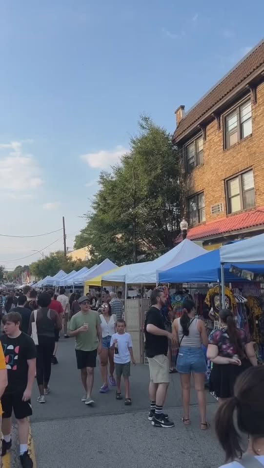 People browsing stalls at a Pittsburgh night market in autumn.