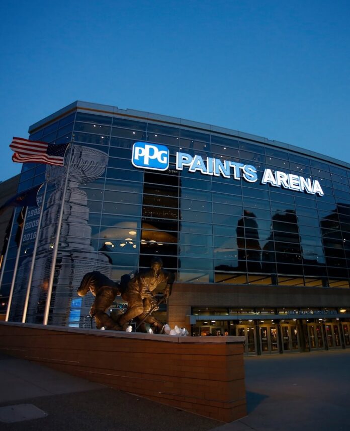 PPG Paints Arena exterior at dusk, featuring the arena's name and a hockey statue.