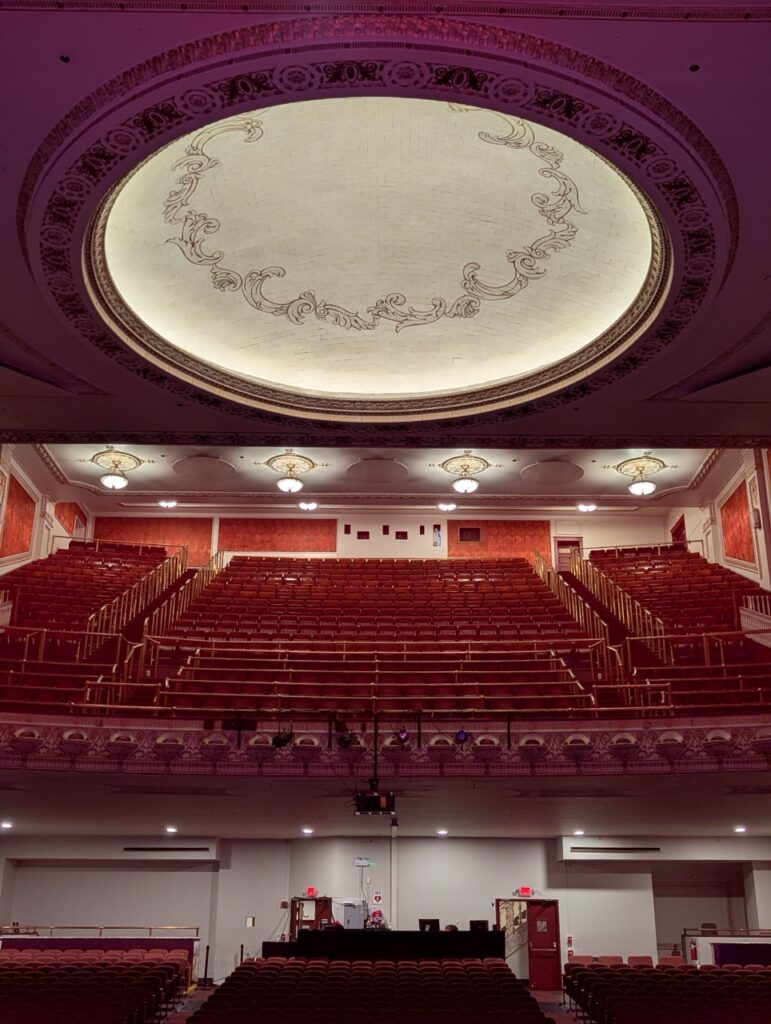 Palace Theatre auditorium with red velvet seats and ornate dome ceiling.