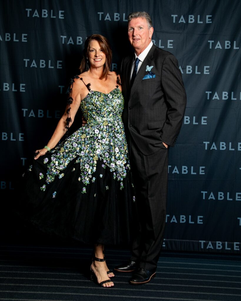 Couple posing for a photo at an event with TABLE branding