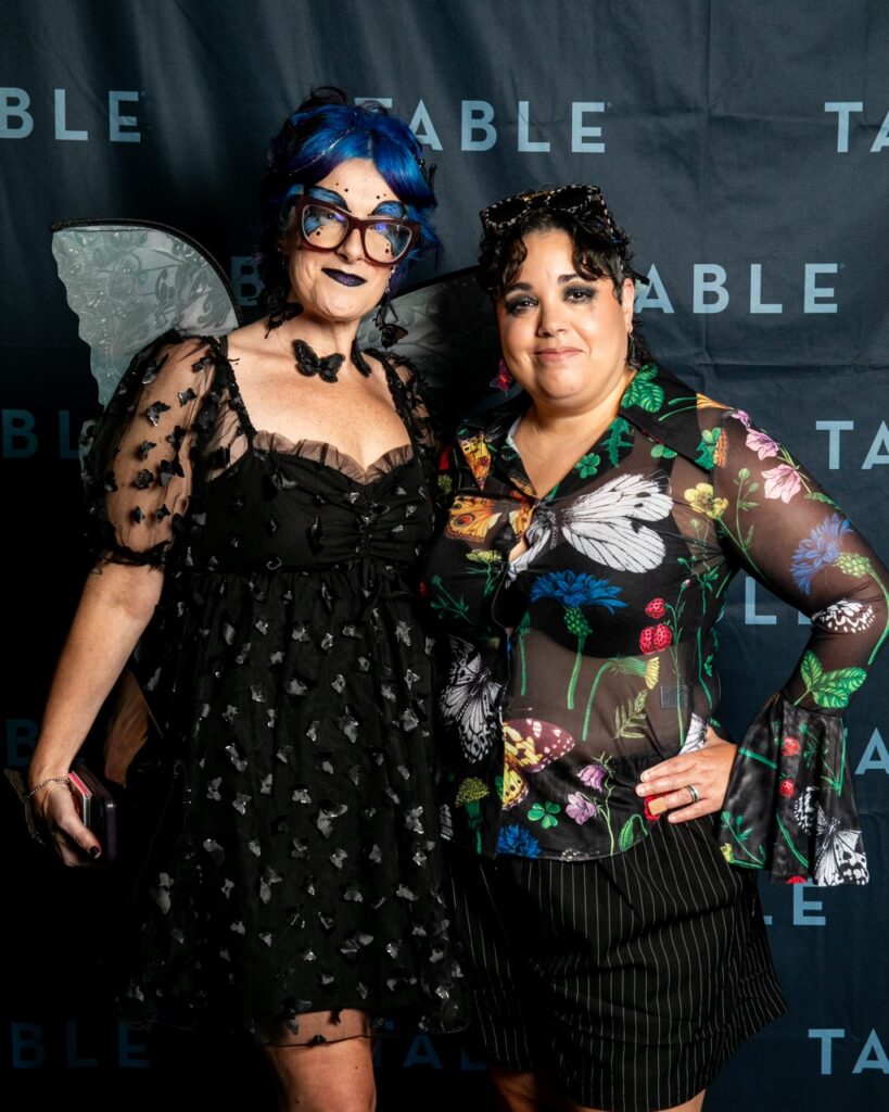 Two women in whimsical fairy-inspired outfits pose for a photo