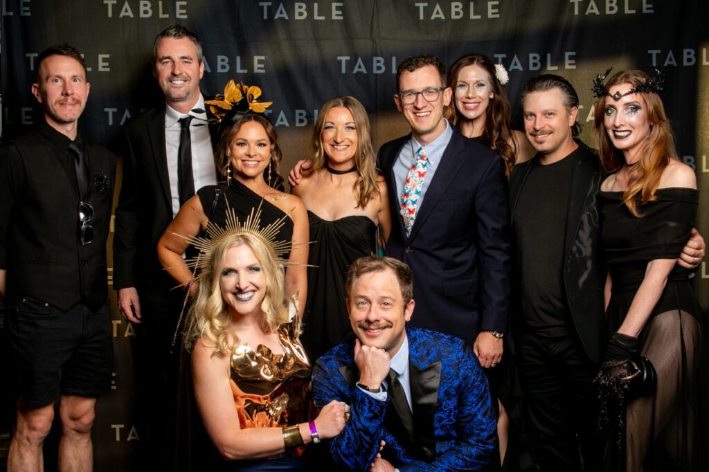 Group of people posing for a photo at an event with "TABLE" branding