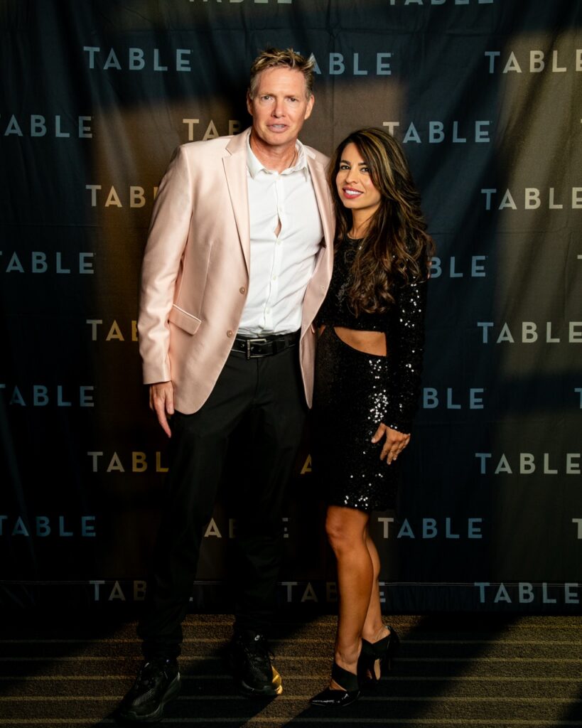 Man in pink blazer and sequined dress woman pose at TABLE event