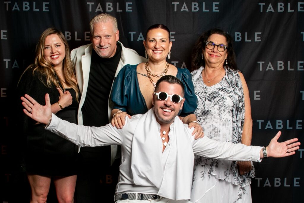 Five people pose for a photo at a TABLE event, with a man in front.