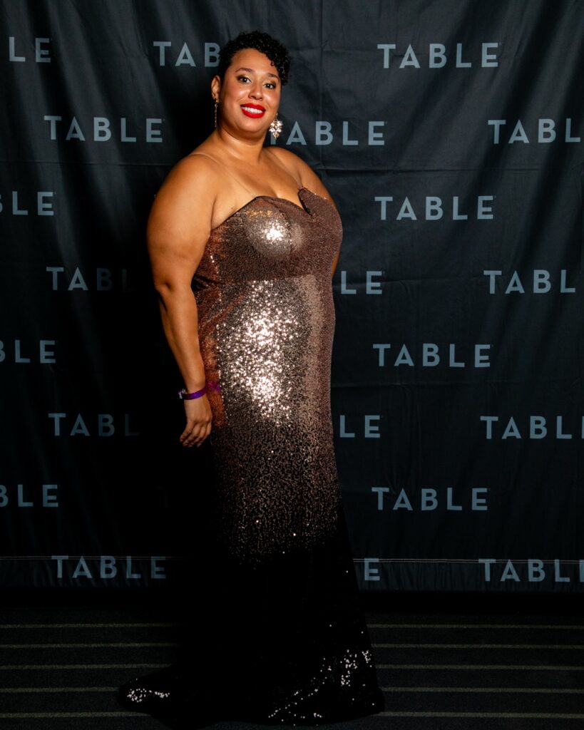 Plus-size woman in a sparkling rose gold and black sequin gown at an event