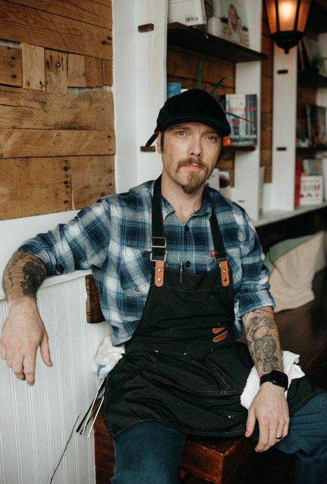 Peter Henry Scratch And Co TABLE Magazine Peter Henry, chef at Pittsburgh's Scratch & Co., wearing a plaid shirt and apron.