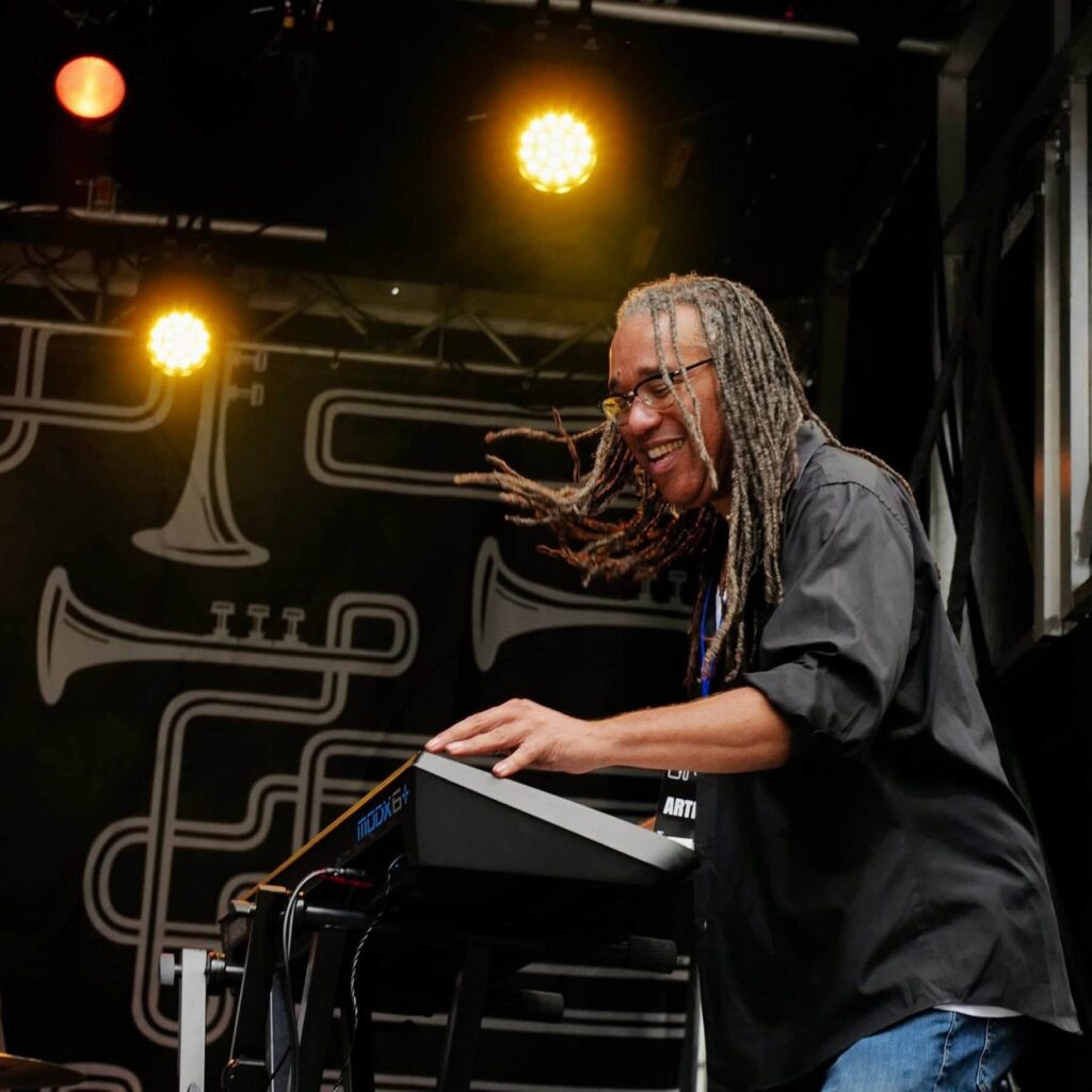 Keyboardist with dreadlocks playing at a Pittsburgh music event