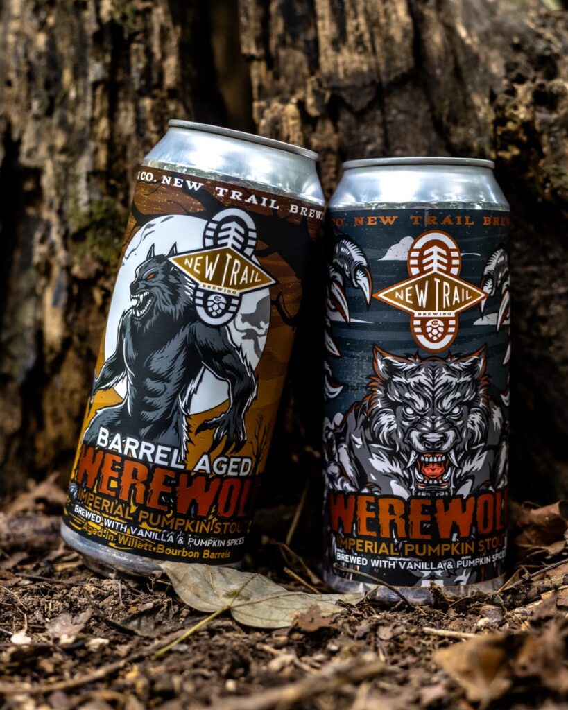 Two New Trail Brewing "Werewolf" pumpkin stout cans, one barrel-aged, outdoors