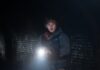 Collier’s Cuts: Director Zach Cregger Follows ‘Weapons’ with a New ‘Resident Evil’ Movie Austin Abrams traveling through a bloody dark tunnel with a flashlight in Resident Evil.