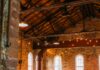 Honoring Edna Lewis: Lessons on Food, Tradition, and Family from ‘The Taste of Country Cooking’ Wide view of guests seated along a long, candlelit dining table inside a rustic brick event space.