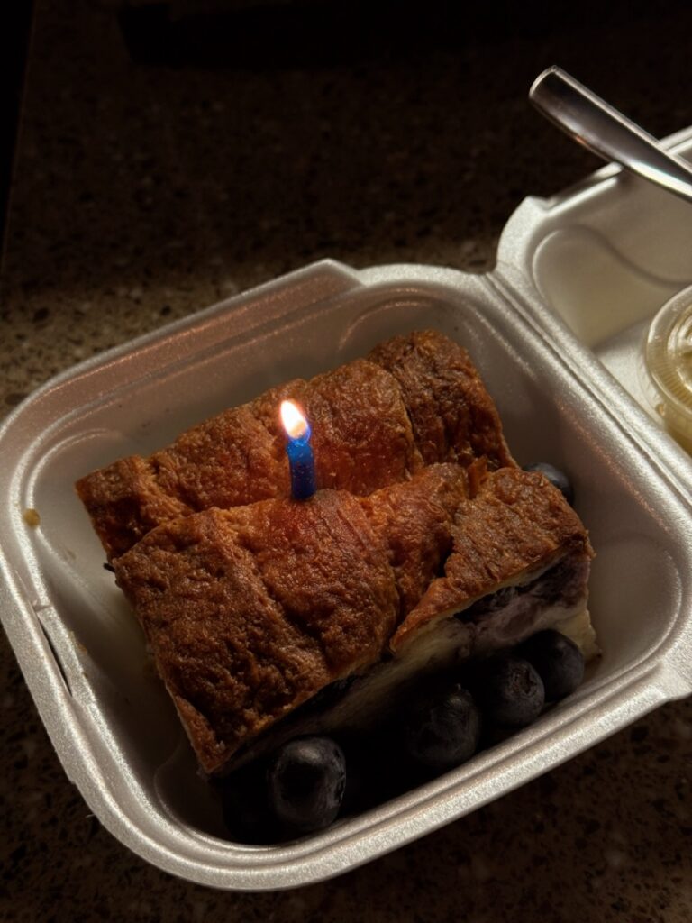 Blueberry cheesecake with a birthday candle in a to-go container, Pittsburgh desserts