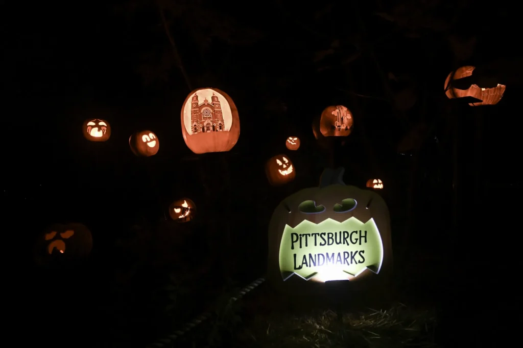 Pittsburgh Landmarks jack o'lantern display at night, with carved pumpkins.