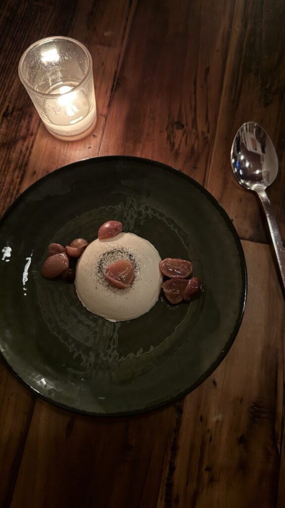 Creamy panna cotta with roasted grapes and black pepper, a Pittsburgh dessert.
