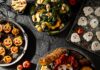 8 Spooky-Good Halloween Party Recipes for Home or Office Spooky Halloween party food spread with ghost cookies, skull charcuterie, and pumpkin appetizers