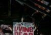 How Author Daniel Kraus Is Keeping George A. Romero’s Horror Legacy Alive Daniel Kraus's "The Living Dead" novel held by monster claws, honoring Romero's legacy.