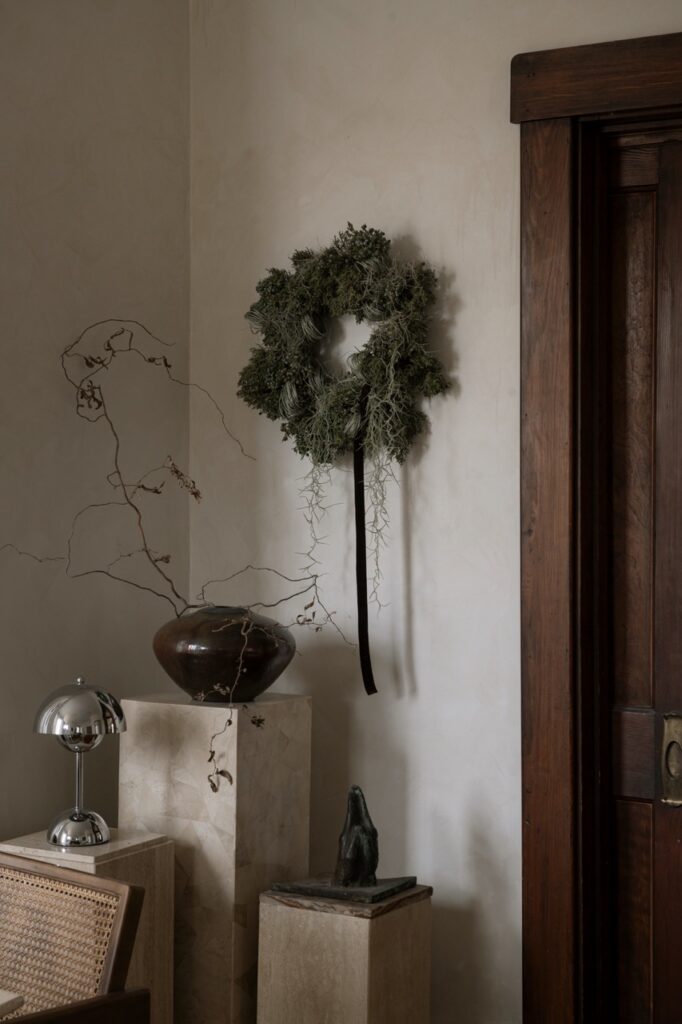 Foraged holiday decor: moss wreath and branches in vase by Erin Kelly