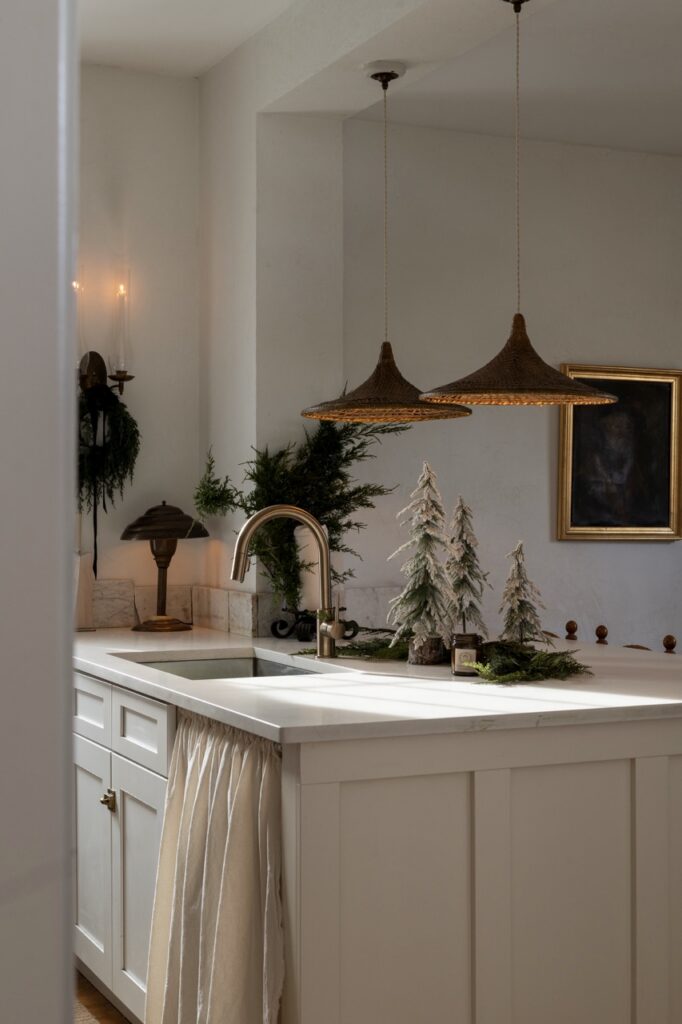 Foraged holiday decor with miniature trees and greenery on kitchen island