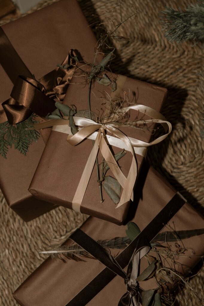 Foraged holiday decor: brown paper gifts tied with ribbons and natural elements.