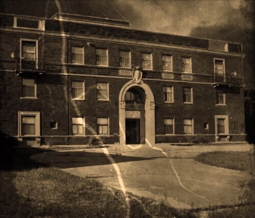 Old brick building with arched entryway, possibly haunted for Pittsburgh tours.