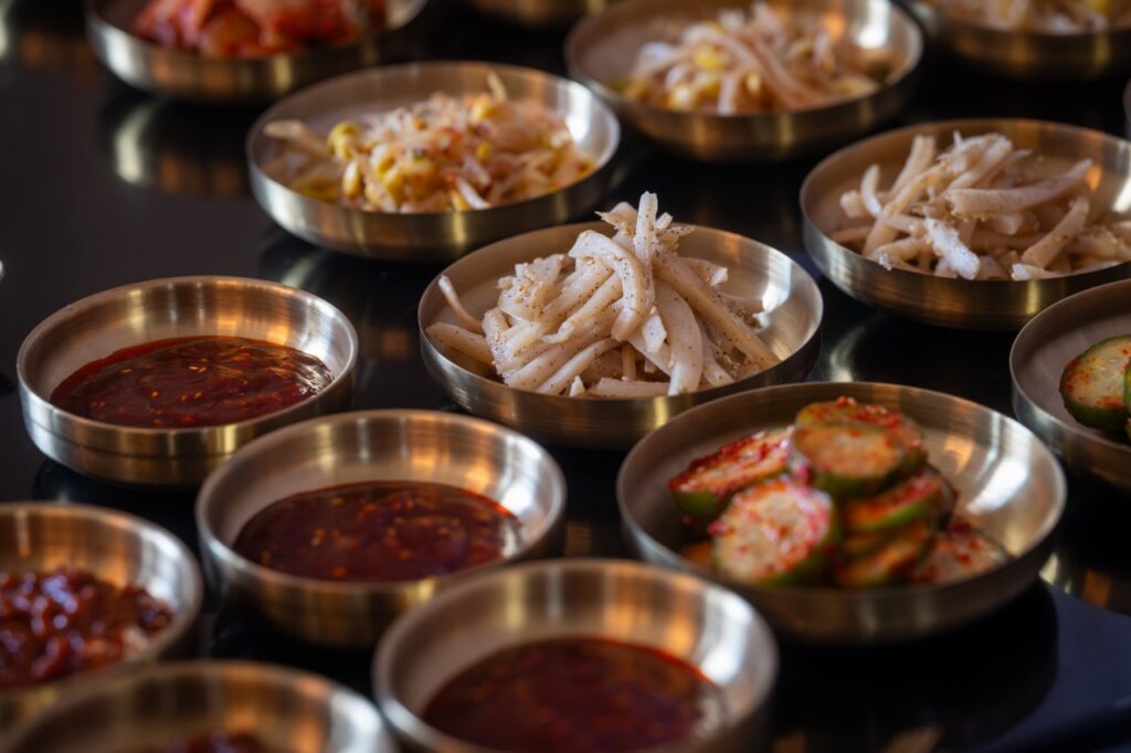 Assortment of Korean banchan side dishes in small brass bowls