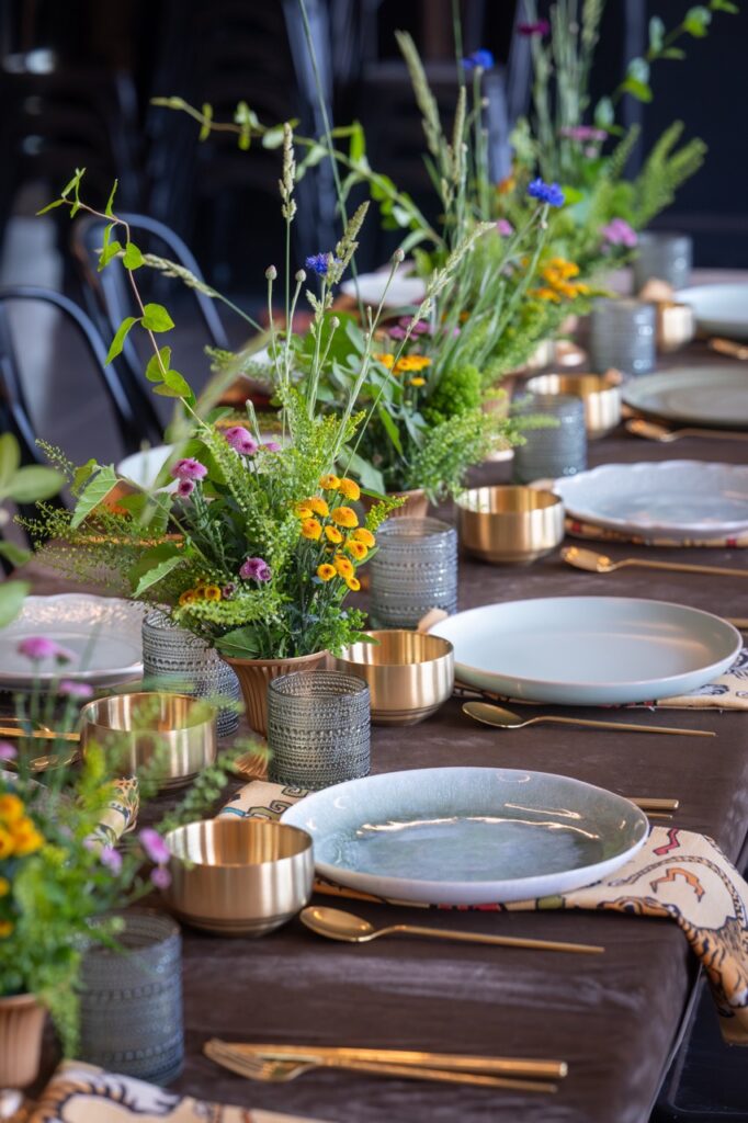 Table setting with floral arrangements, gold accents, and place settings