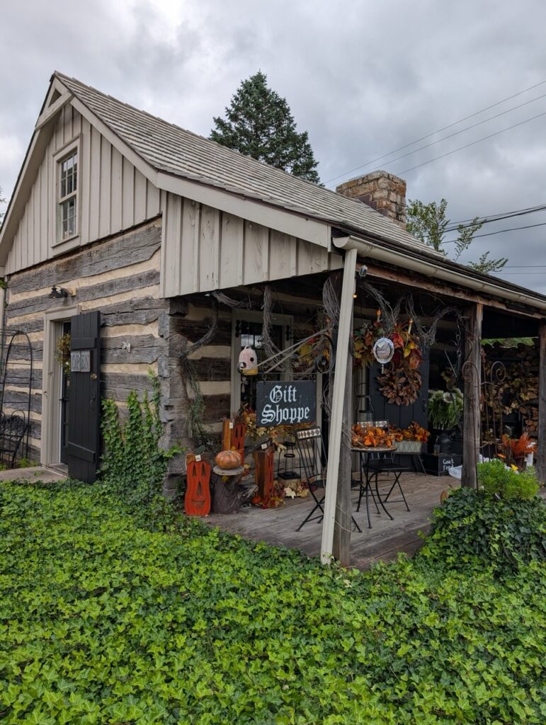 Jean Bonnet Tavern gift shoppe with fall decorations and historic log cabin exterior.