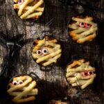Individual mini cast-iron crocks filled with Shepherd's pie and topped with piped mashed potato mummy wraps and candy eyeballs.