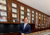 Hidden Treasures: The Stories, Beauty, and Value Behind Rare Coins with Olevian Numismatic Rarities Man in suit standing in coin dealership with display cases of graded coins.