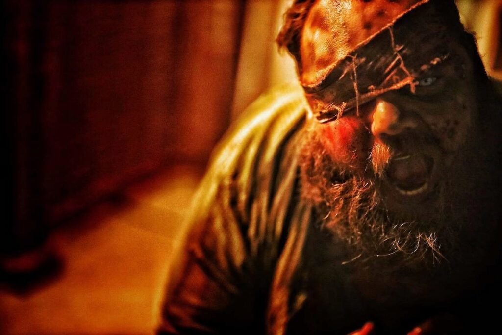 Scary masked figure with glowing eyes at Portals of Fear haunted attraction