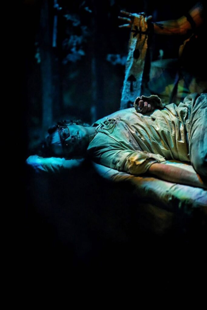 Man in a haunted attraction bed at Portals of Fear