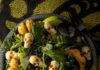 Roasted Squash Salad with Mozzarella Skulls for Halloween A serving bowl of roasted squash salad with kale, apple, and pepitas, topped with mozzarella skulls for Halloween.