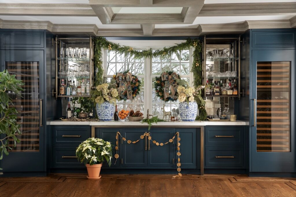Luxurious holiday home bar with festive floral decor and wreaths.