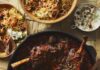 8 Lamb Recipes to Celebrate 35 Years of ‘The Silence of the Lambs’ Persian lamb stew for Nowruz, staged with other sides on a light brown table.