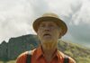 Collier’s Cuts: Martin McDonagh Treads Familiar Ground With Considerable Style in ‘Wild Horse Nine’ A man stands in an orange button down shirt with black suspenders and a brown hat in Wild Horse Nine.